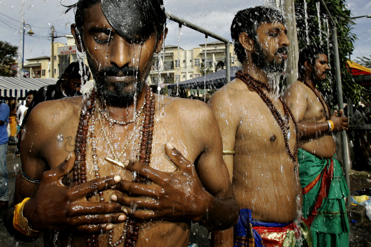 Hindus take a ceremonial shower near the Batu Caves temple during Thaipusam in 2008. – AFP pic
