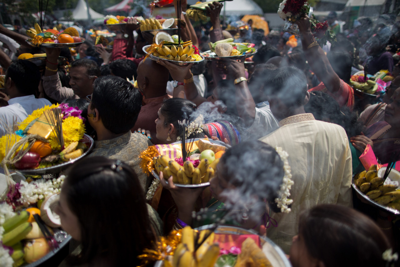 Hindu devotees carry free food offerings as they pray in front of Lord Muruga's silver chariot during the Thaipusam Hindu festival in Penang on January 16, 2014. – AFP pic 