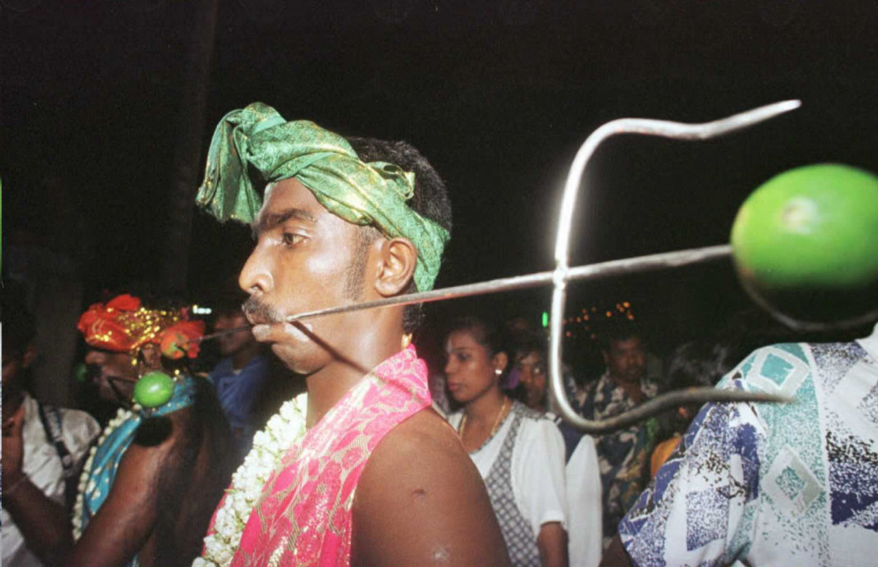 A Hindu devotee with a spear pierced through his cheeks takes part in the Thaipusam festival to fulfil a vow to Lord Murugan at the Batu Caves temple on February 4, 1996. – AFP pic