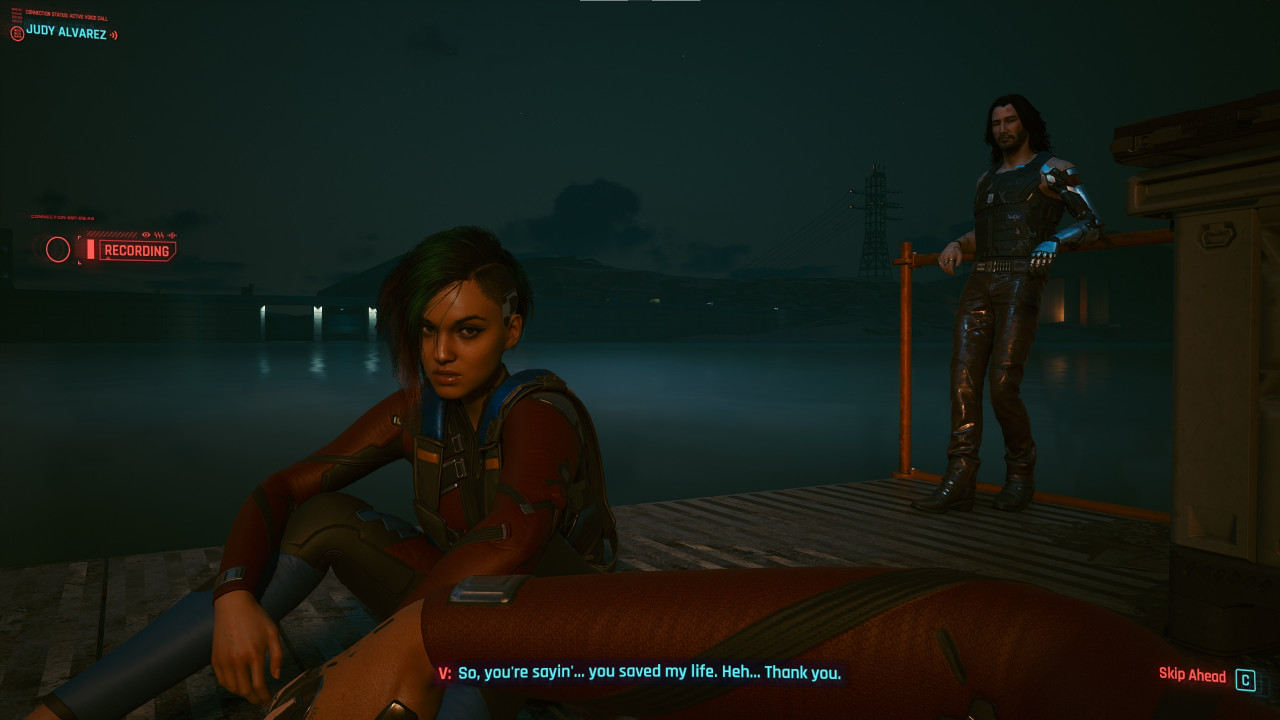 Troubled hacker Judy Alvarez (L) and deceased rocker-turned-apparition Johnny Silverhand (Keanu Reeves) looks at the protagonist during a light moment. – Screenshot