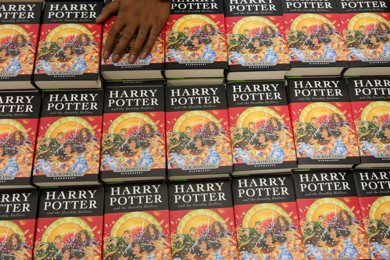 A bookstore assistant stacks copies of 'Harry Potter and the Deathly Hallows', the seventh and final episode at the Borders bookstore in Singapore, July 21, 2007. - EPA pic