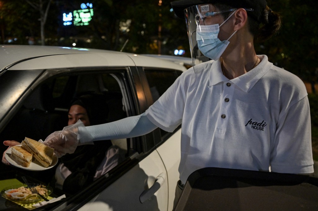 A waiter serving a customer using the 'dine-in car' service. It proved such a hit they have now opened a second at another outlet in the city. –  AFP pic