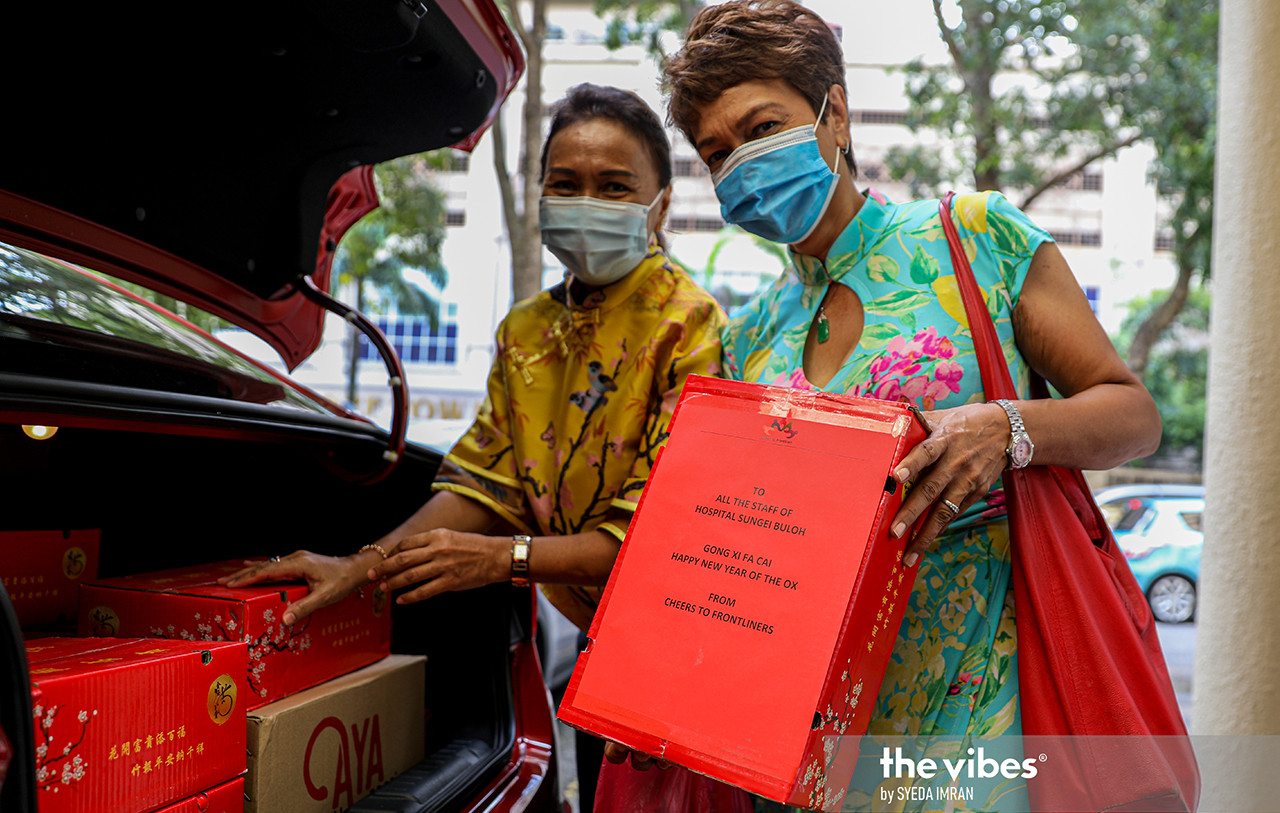 Roselina (left) and Ungku Shakirah loading their car with CNY goodies for the frontliners. – SYEDA IMRAN/The Vibes pic