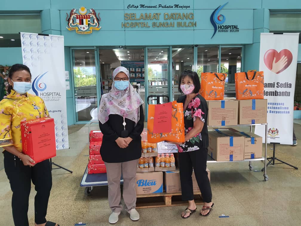(From left) Roselina, Dr Nurul Jannah from the Covid Response Unit and Chang handing over the food. – Pic courtesy of Margaret Chang