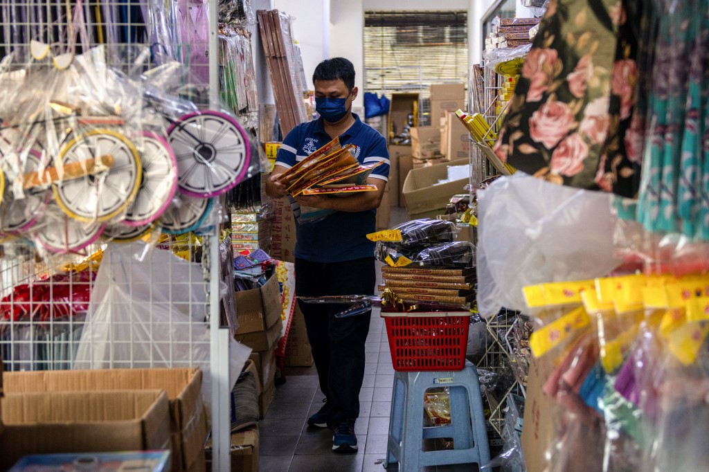 A worker inspecting paper offerings for sale ahead of the Qingming festival. – AFP pic