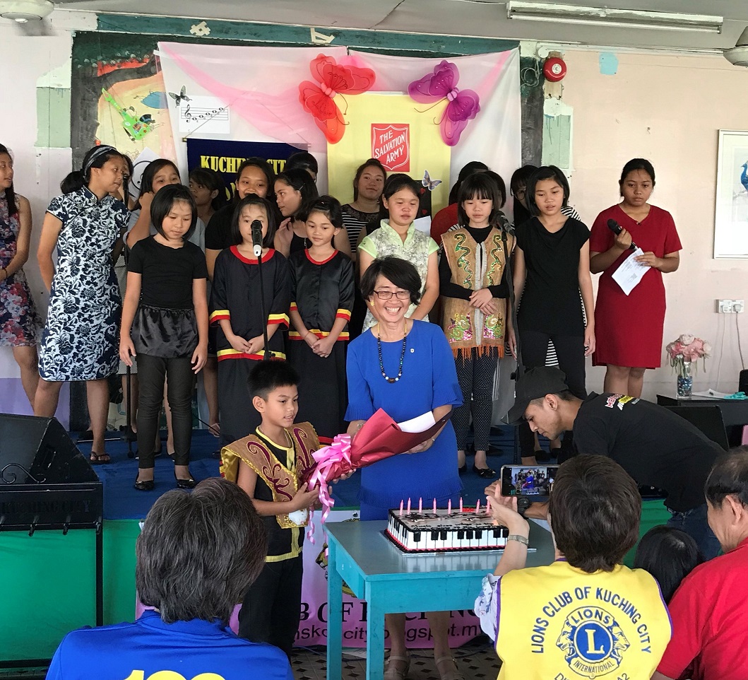 Lim Wee Nee (2nd from R), after a concert staged by the Salvation Army Children's Home in April 2018, watching as a child in a Kenyah costume gives a bouquet to music tutor Dr Chong Pek Lin.  – Pic courtesy of Dr Chong Pek Lin