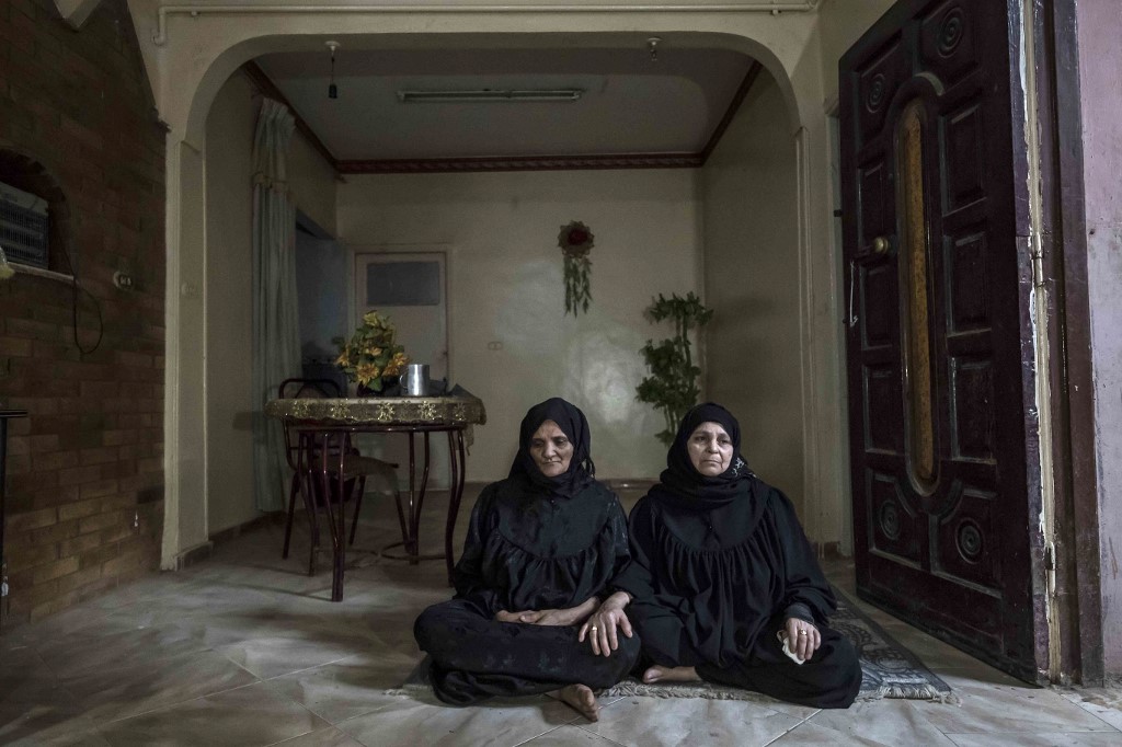 Egyptian mother Fadilaa Ali (left) and her relative Zenab Abdelmoulaa lament over relatives among 17 Egyptians who went missing in Libya while trying to get to Europe. – AFP pic, October 5, 2020