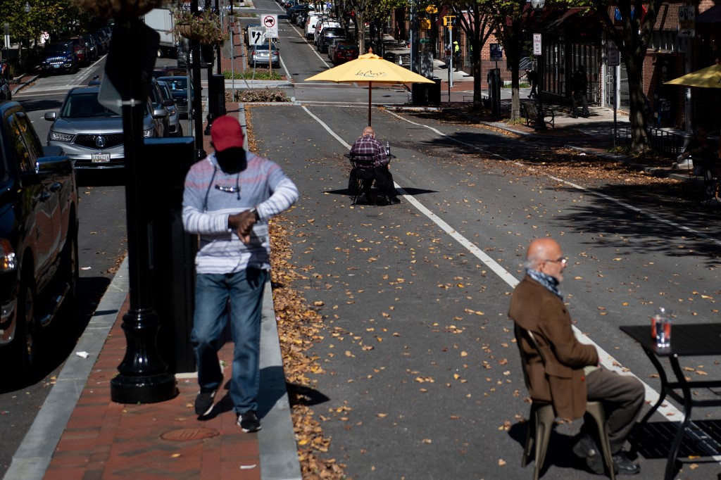 People eat outside on a closed street to combat Covid-19 in the Charles Village neighborhood on October 14, 2020, in Baltimore, Maryland. Demon Lane says his east Baltimore neighborhood will still be blighted by drug dealing, deadly gunfire, rat-infested vacant houses and hopelessness, no matter who wins America's presidential election in November. – AFP pic, October 21, 2020