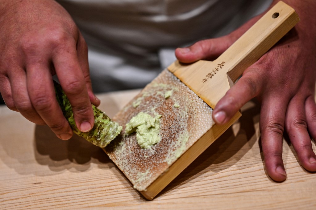 In this picture taken on December 1, 2020, Japanese sushi master Toshiya Matsushita shreds fresh wasabi at his restaurant in Tokyo. – AFP pic