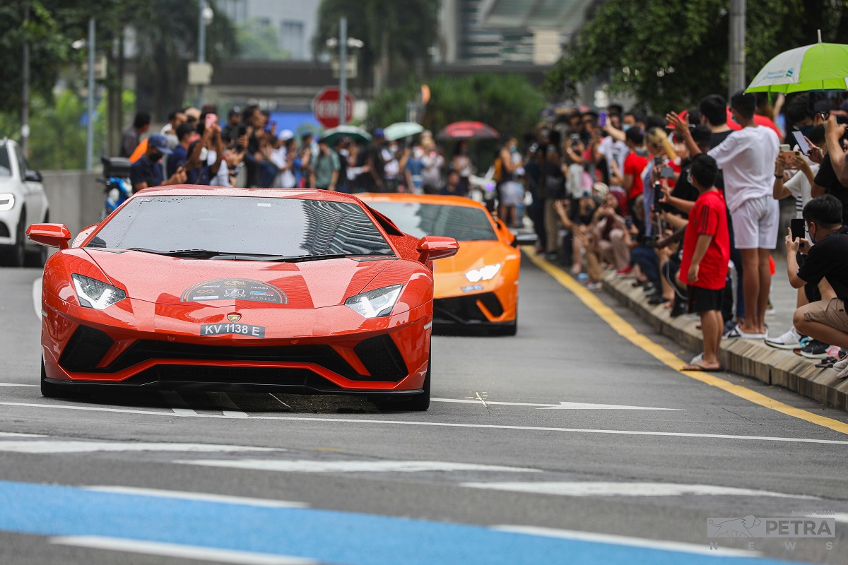 The crowd cheers and waves at drivers as supercars zoom across the road in a rainbow of colours.  – ALIF OMAR/The Vibes pic, June 12, 2022