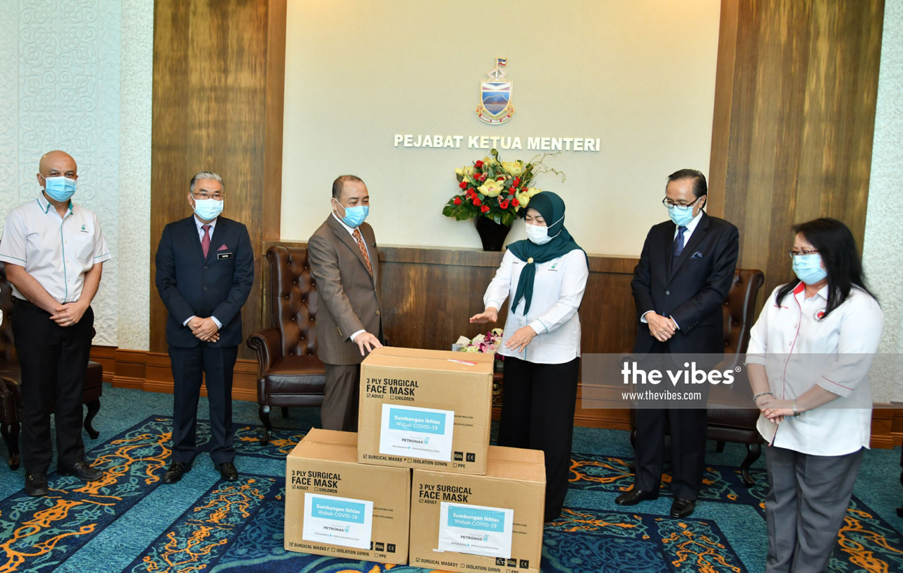 Petronas Sabah & Labuan Head, Rokiah Sulaiman (third right) presenting the masks to Chief Minister Datuk Seri Haji Hajiji Haji Noor (fourth left) as Datuk Masidi Manjun (second left), State Secretary Datuk Safar Untong (third left) and State Health Director, Datuk Christina Rundi (right) look on. Also seen is Petronas Sabah & Labuan Head (Operation) Jasper Diego (second left) and Petronas Sabah & Labuan Manager, Programme Execution, Victoria Jingulam (left). – The Vibes pic, November 13, 2020.