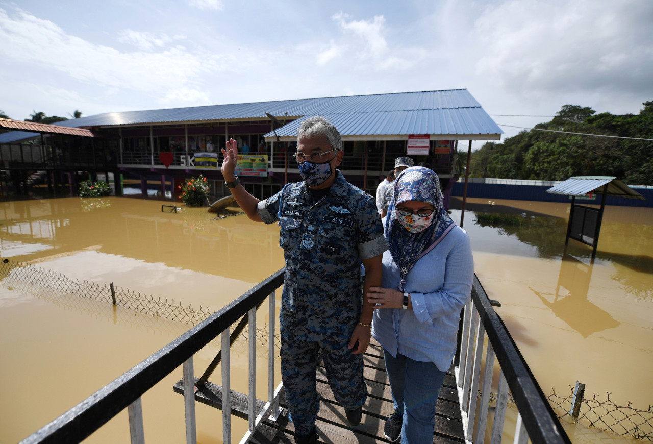 Yang di-Pertuan Agong Al-Sultan Abdullah Ri’ayatuddin Al-Mustafa Billah Shah and Raja Permaisuri Agong Tunku Hajah Azizah Aminah Maimunah Iskandariah making their way into the SK Kg Aceh flood relief centre to hand out aid and check on victims of the natural disaster. – Bernama pic, January 14, 2021