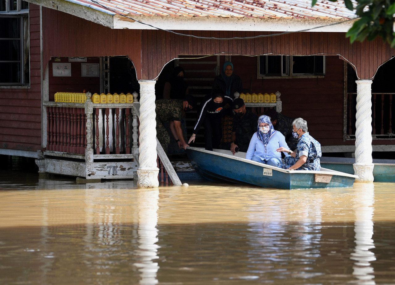 Tengku Puteri Raja Tengku Puteri Jihan Azizah Athiyatullah being helped into a boat with the Yang di-Pertuan Agong Al-Sultan Abdullah Ri’ayatuddin Al-Mustafa Billah Shah and Raja Permaisuri Agong Tunku Hajah Azizah Aminah Maimunah Iskandariah as they prepare to check on the area inundated by floodwaters in Kg Tg Medang, Pekan, today. – Bernama pic, January 14, 2021