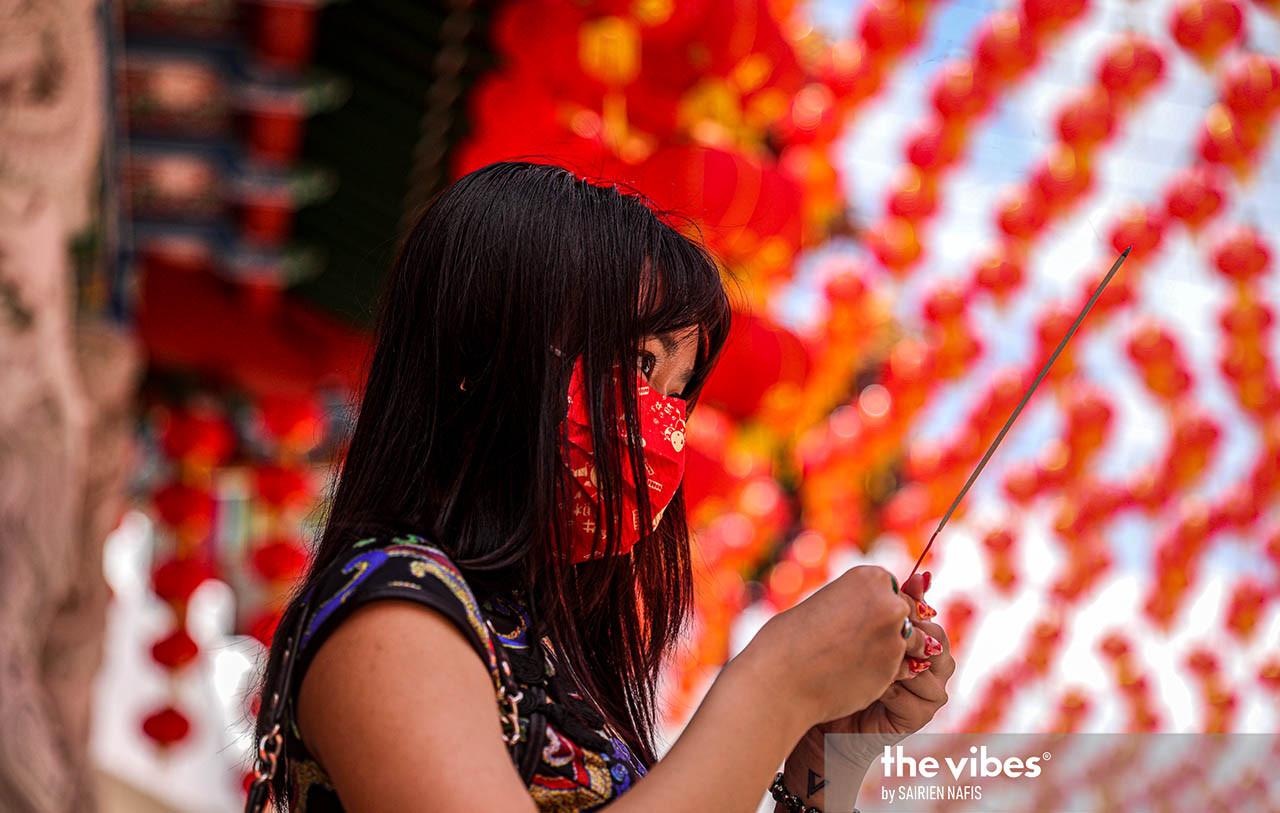 A devotee holding up an incense stick at the Thean Hou Temple. Incense is burned for multiple occasions and reasons, from paying respects to ancestors to warding off bad luck. – SAIRIEN NAFIS/The Vibes pic, February 26, 2021