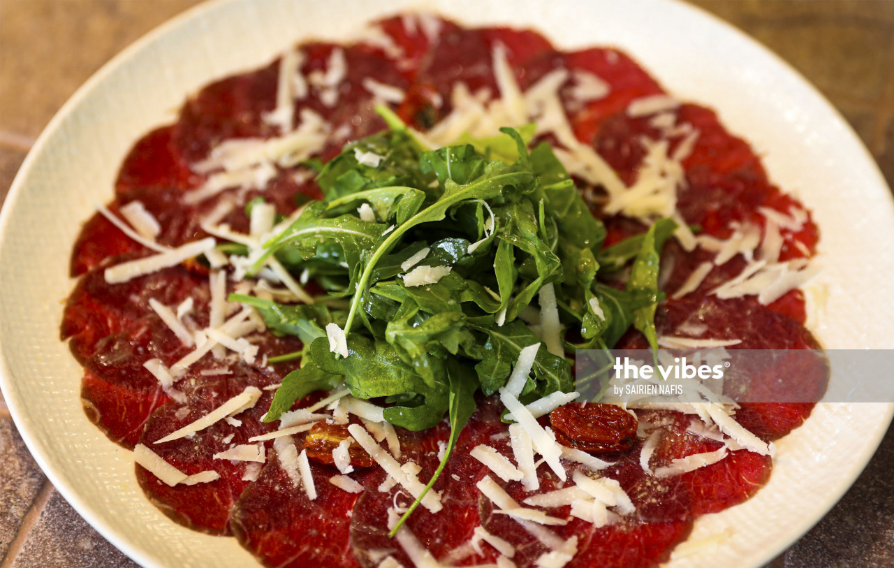 Carpaccio di Manzo, which is Australian beef carpaccio served with rocket salad, Grana Padano, cherry tomato confit  and lemon dressing. – The Vibes pic