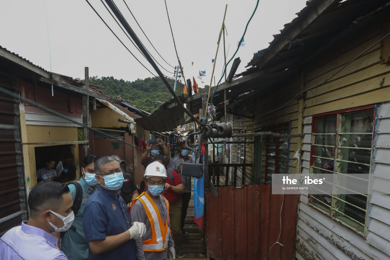 Energy and Natural Resources Minister Datuk Shamsul Anuar Nasarah looking at the illegal electrical wiring during his visit to Kg Numbak on Thursday. – The Vibes pic, September 19, 2020