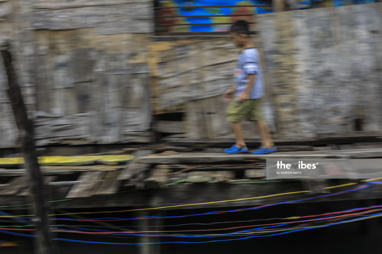 A boy passing by some tangled electric cables in Kg Numbak. – The Vibes pic, September 19, 2020