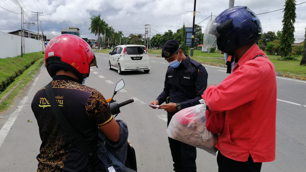 A police officer inspects a driver heading to Papar near the Taman Pantai Lokkawi. – The Vibes pic, October 3, 2020