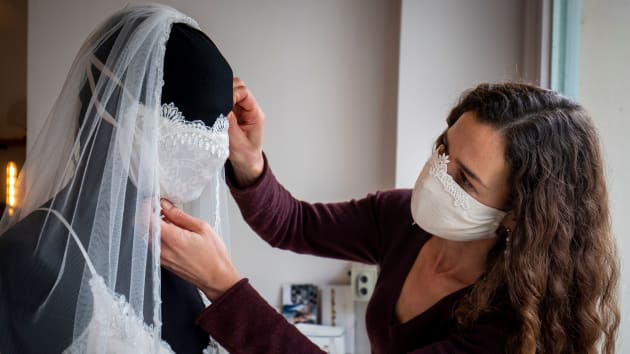 Wedding dress and evening wear designer Friederike Jorzig adjusts a mannequin wearing a wedding dress with matching protective mask in her store Chiton in Berlin on March 31, 2020. – AFP pic, October 15, 2020