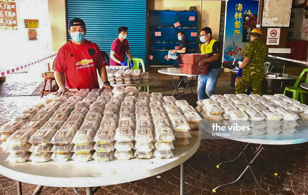 Service centre chief liaison officer Patrick Chia (left) with the centre's takeaway lunch boxes prepared for the needy and frontliners. – NEIL CHAN/The Vibes pic, November 12, 2020