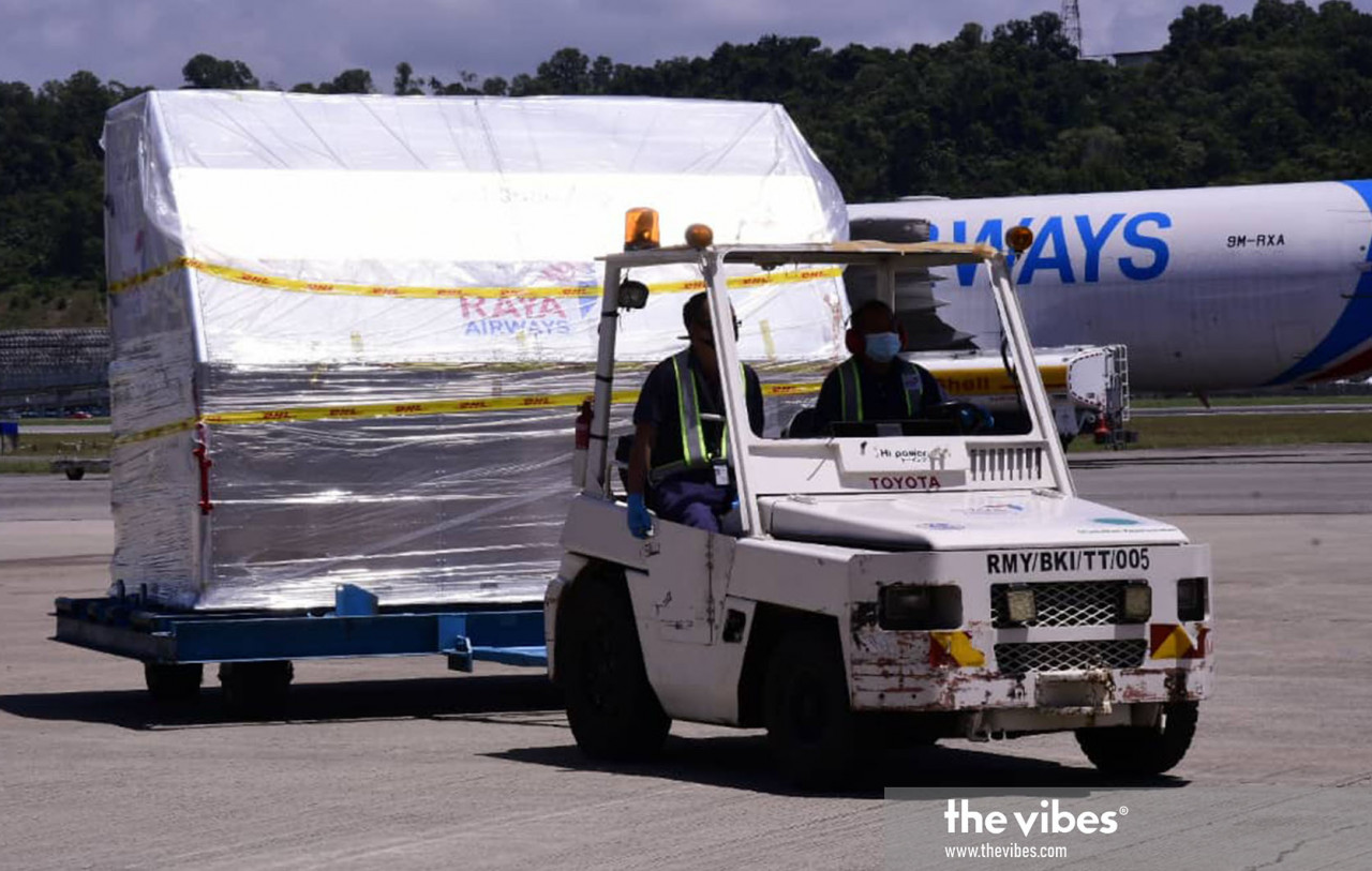 Airport workers pulling one of the few consignments filled with the Covid-19 vaccine, 16,380 doses of which were received by Sabah today. – The Vibes pic, February 25, 2021