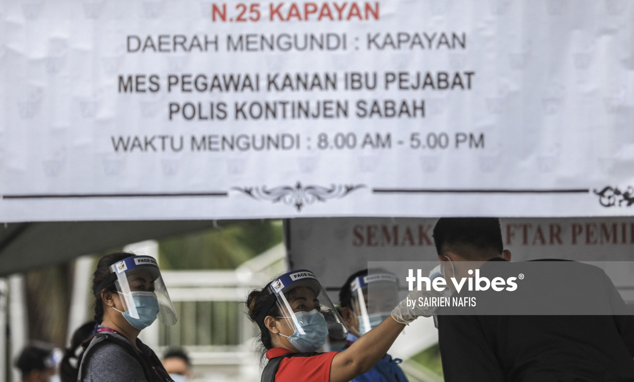 Voters get their temperature checking in Kepayan. – The Vibes pic, September 22, 2020
