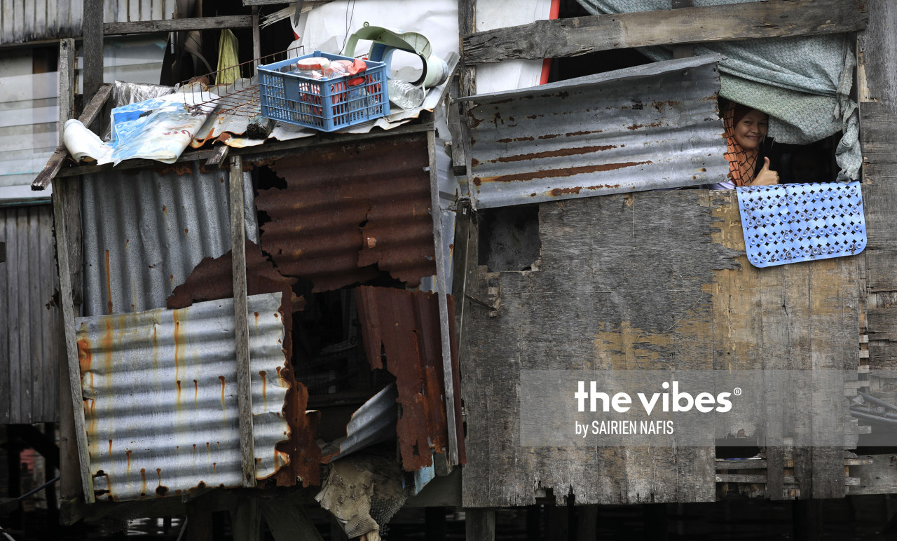 A woman giving a thumbs-up through the window of her dilapidated home in Kg Numbak. – The Vibes pic, September 24, 2020