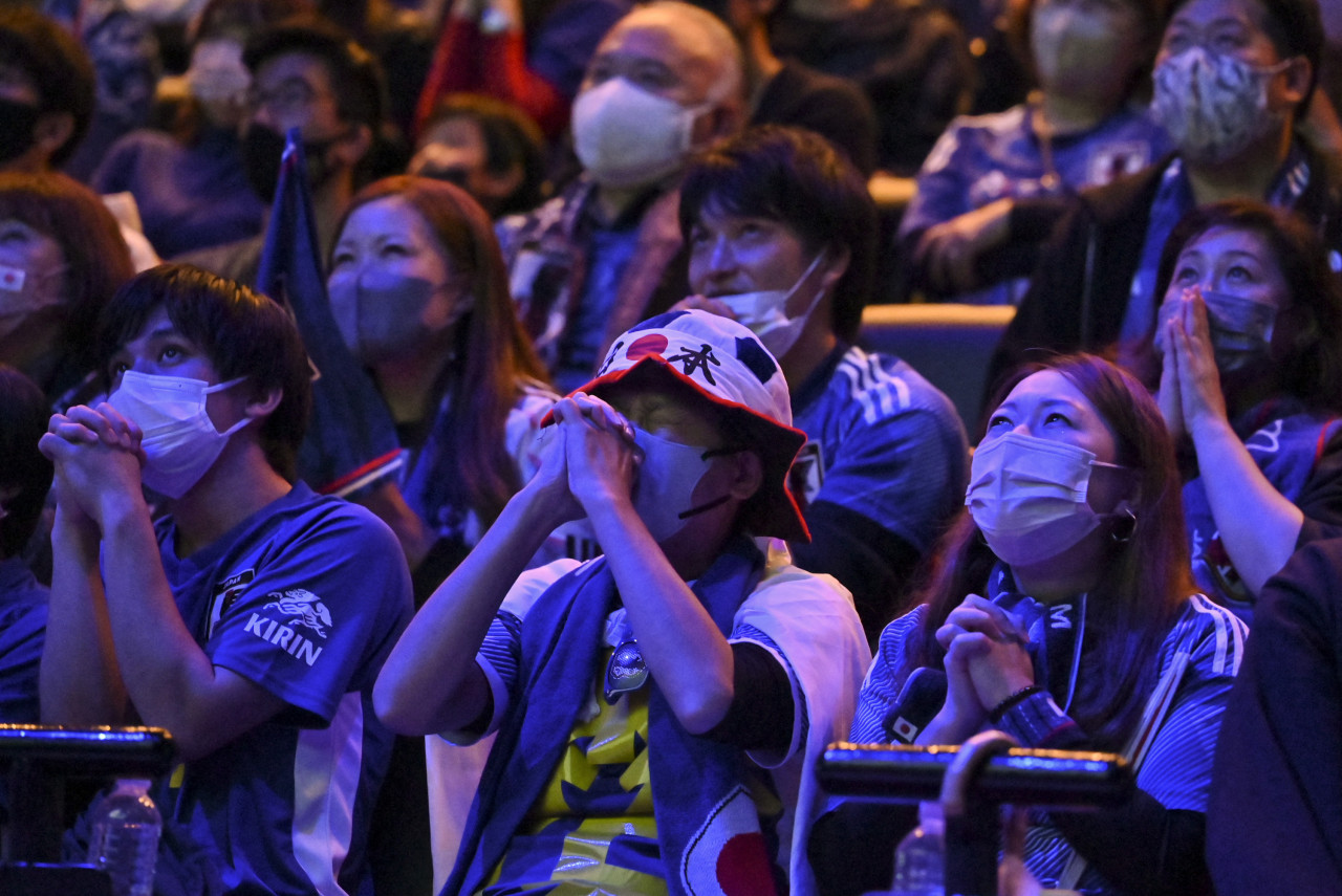 Fans react as they wait for the clock to click down toward the end of the game while watching the Qatar 2022 World Cup Group E football match between Germany and Japan, being shown at a fan zone event in Tokyo. - AFP pic, November 23, 2022