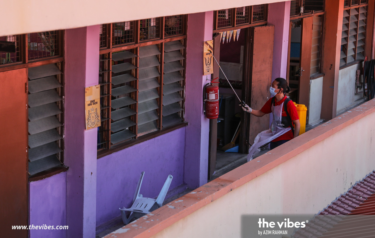 A volunteer sprays classroom ventilation points with disinfectant. – AZIM RAHMAN/The Vibes pic, February 27, 2021
