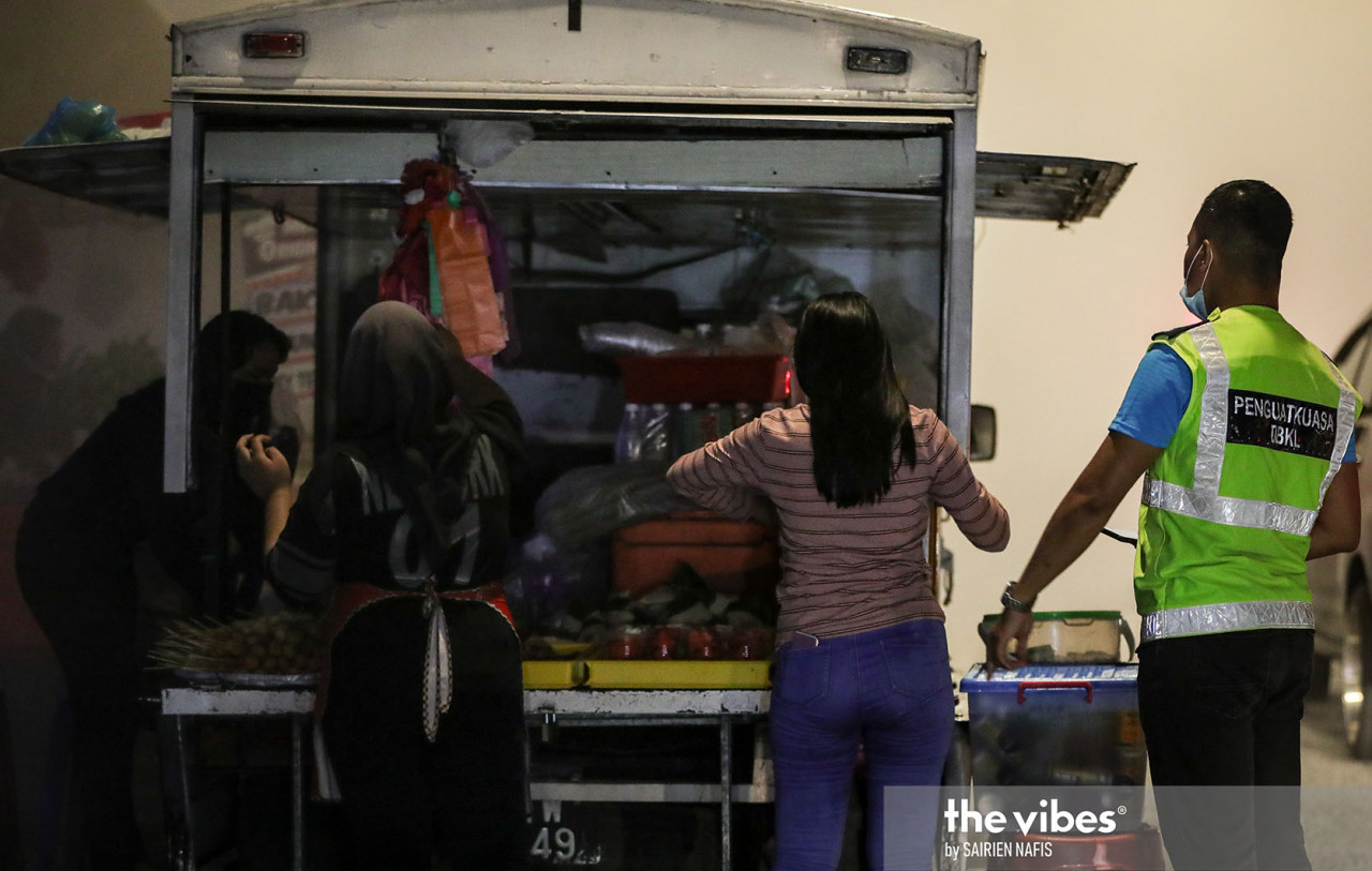 A DBKL officer ordering a food truck to close near the city's River of Life. – The Vibes pic, January 1, 2021