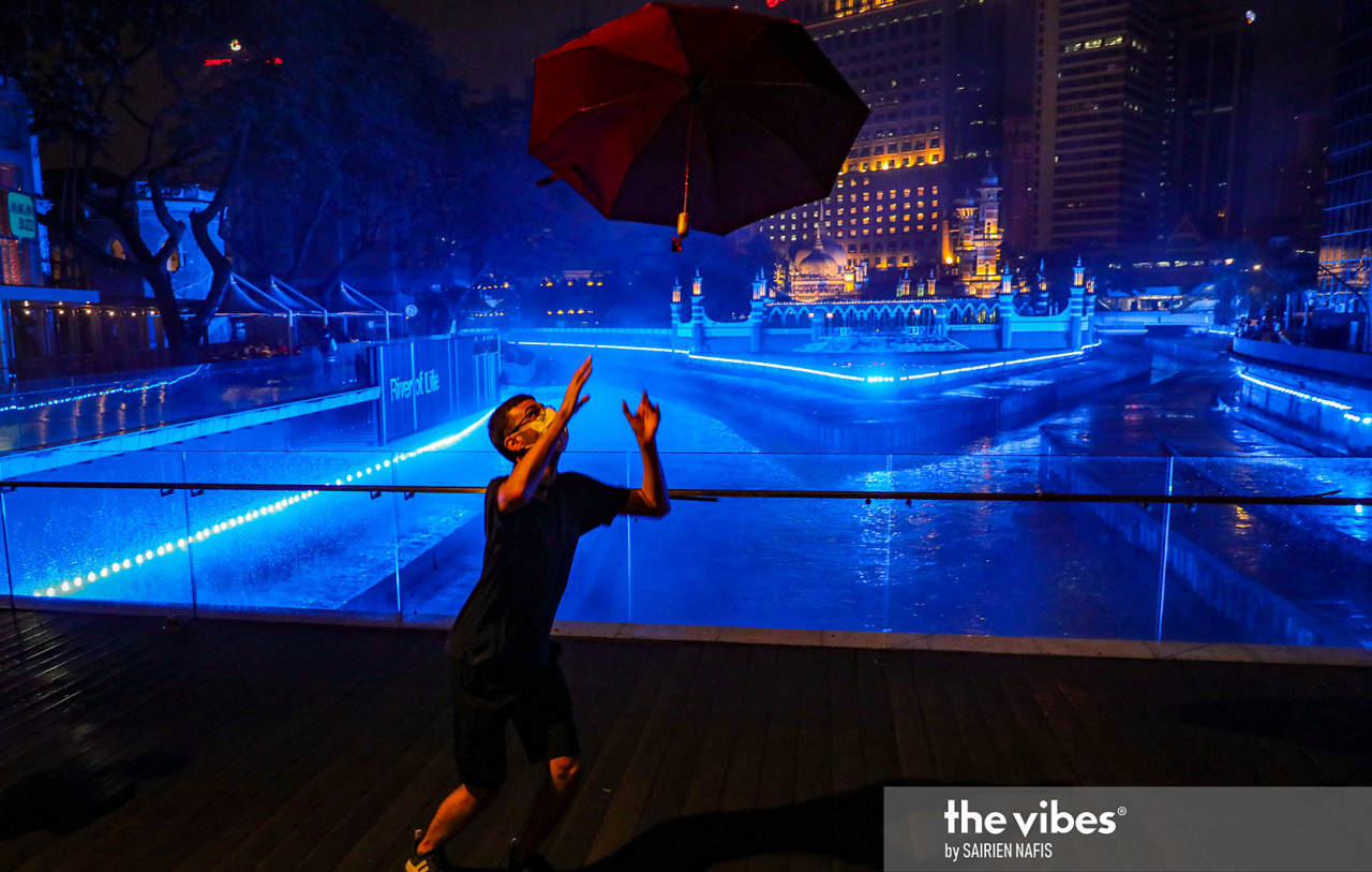 Amid celebrations at the River of Life, a man tosses his umbrella into the air. – The Vibes pic, January 1, 2021