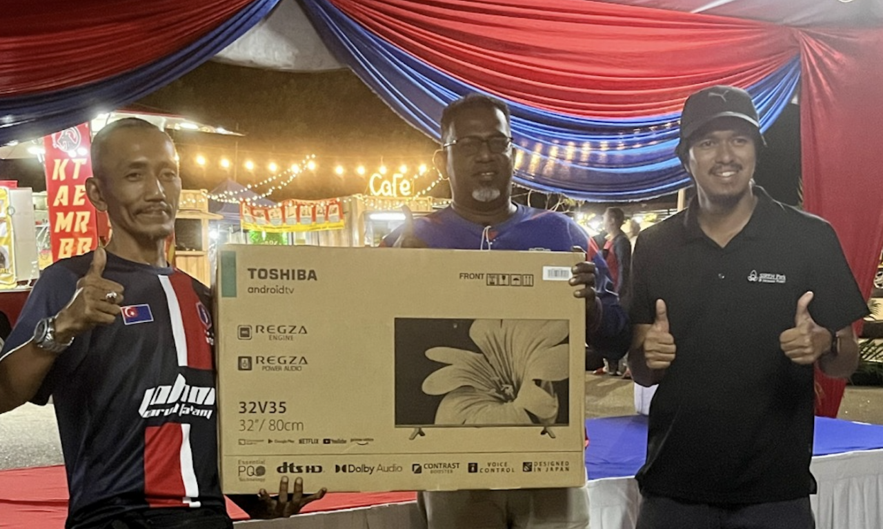 JDT fan Ali Martopo from Pontian (left) returns home with a brand new flat screen television after he was announced as the main prize winner of the event’s lucky draw. – IKHWAN ZULKAFLEE/The Vibes pic, November 27, 2022