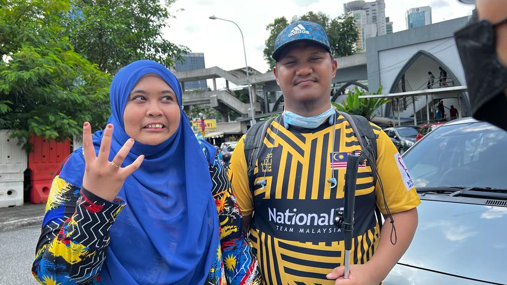 For visually impaired Razlan (right), 28, the Merdeka parade was a giddy delight as he was able to appreciate the nation’s security assets, which has been a long-time fascination of his. – The Vibes pic, August 31, 2022