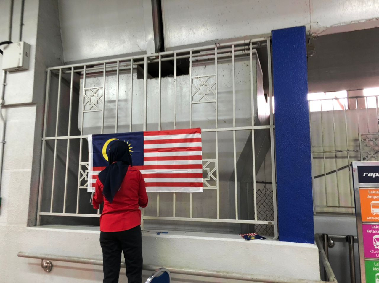 An LRT worker was spotted placing the Jalur Gemilang at the Pasar Seni LRT station. – HAKIM MAHARI/The Vibes pic, August 19, 2022