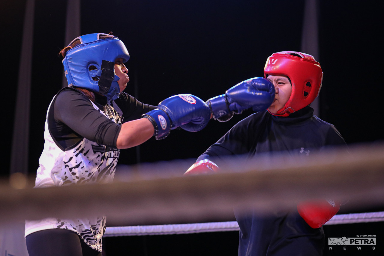 Lina “The Lite X” from Strive Putrajaya throwing a punch at Alia BTK of Jordan Top Team during the fourth bout of the all-women MMA fight organised by an all-women fitness studio, Fitness Champ. - SYEDA IMRAN/The Vibes pic, March 7, 2022 