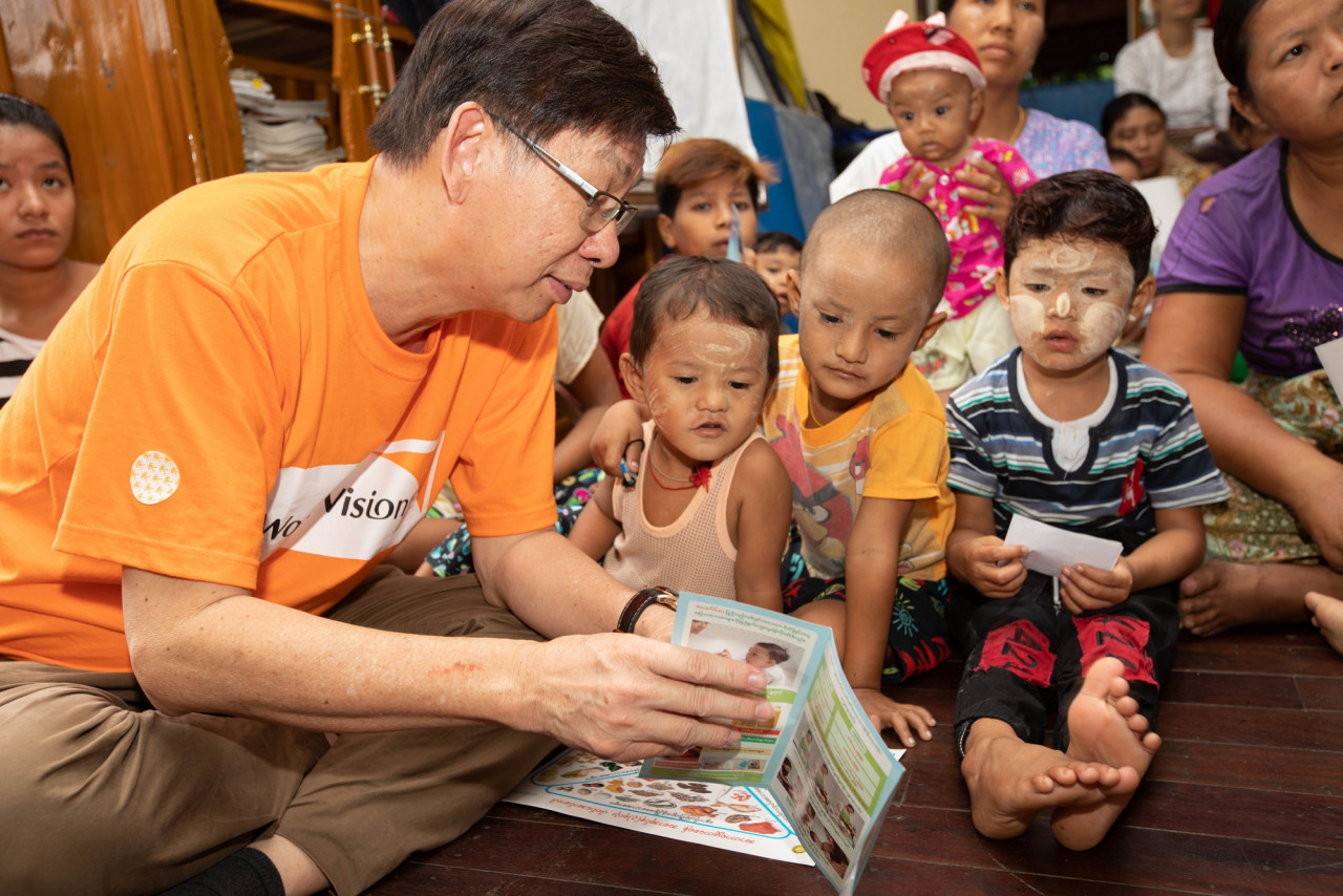 Boey reads a pamphlet on handwashing techniques to young children in Myanmar. - Pic courtesy of WVM
