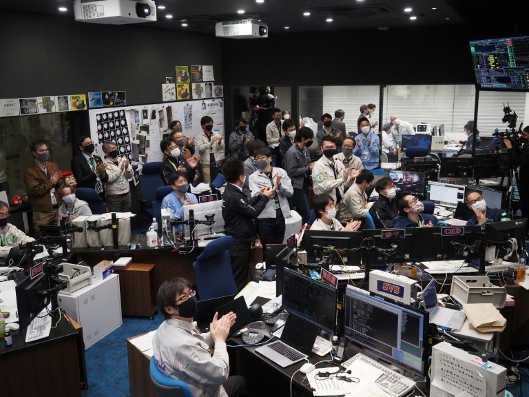Hayabusa-2 project members in the mission control room watch the fireball phase of the re-entry capsule. – AFP pic