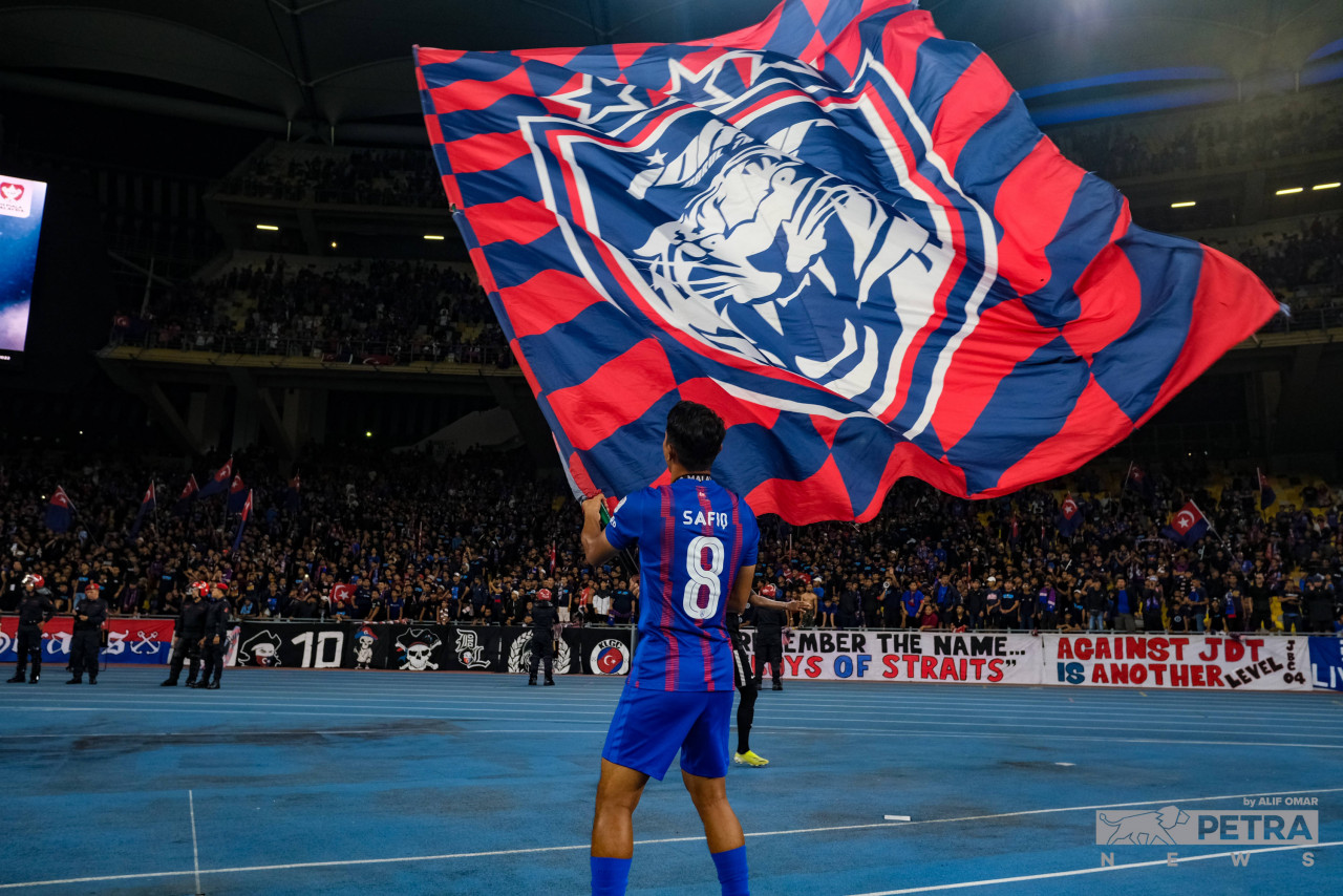 Safiq Rahim of Johor waves the flag in front of over 4,000 JDT fans who travelled north to catch their team play in the finals. – ALIF OMAR/The Vibes pic, December 1, 2022