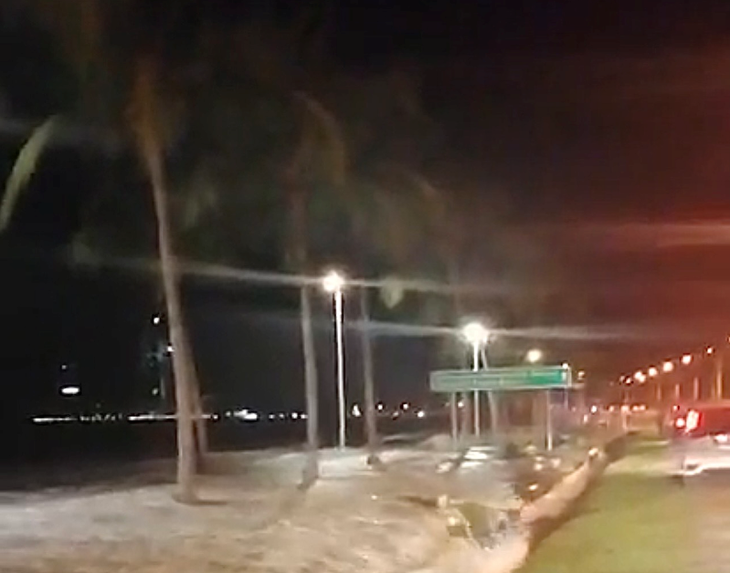 High-tide sees sea water spill onto the Likas Bay highway road. –  Social media pic, January 13, 2021