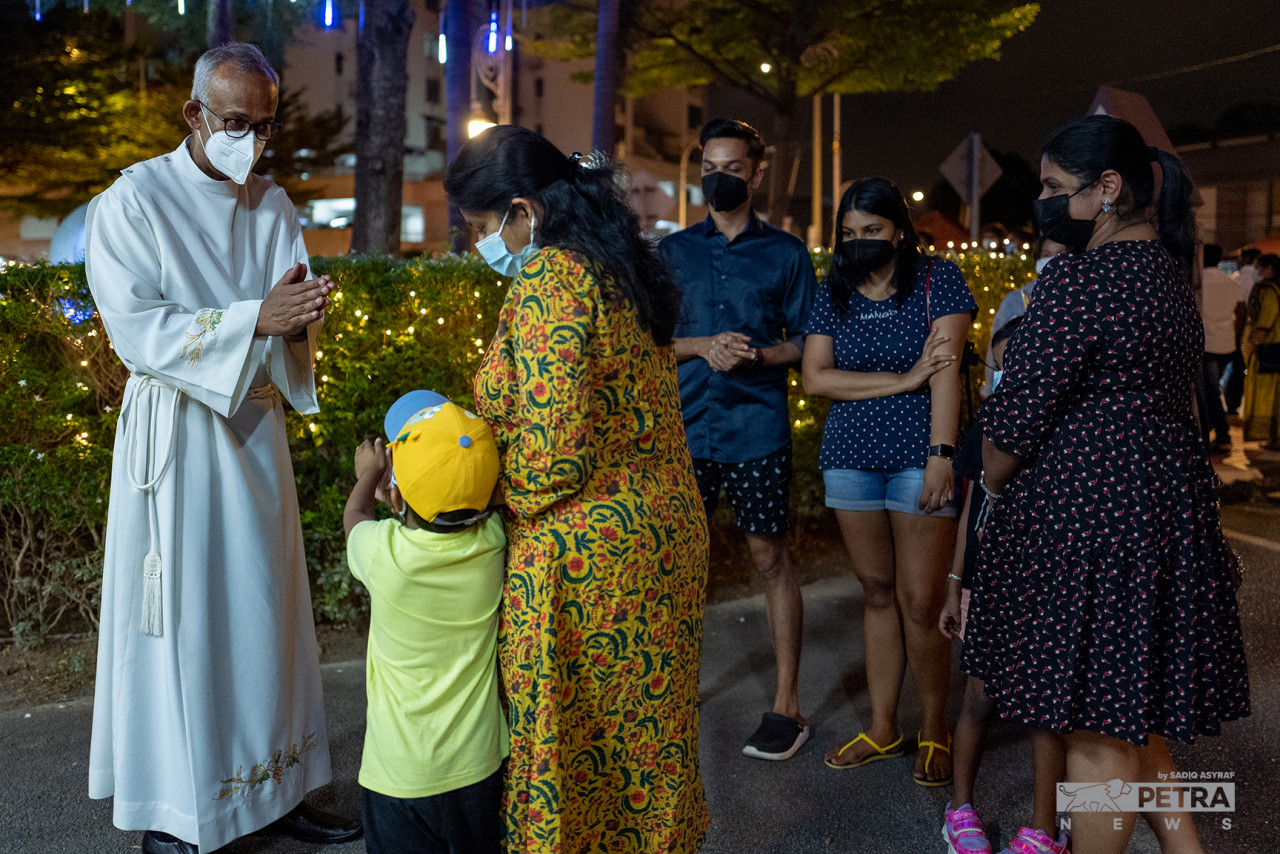 Reverend Father Dr Clarence Devadass attending to the congregation at last night’s Christmas Vigil. One of the most important things he notes that a Christmas Mass can do is let people know they are welcome despite having to control the service to accommodate SOP limitations. – SADIQ ASYRAF/The Vibes pic