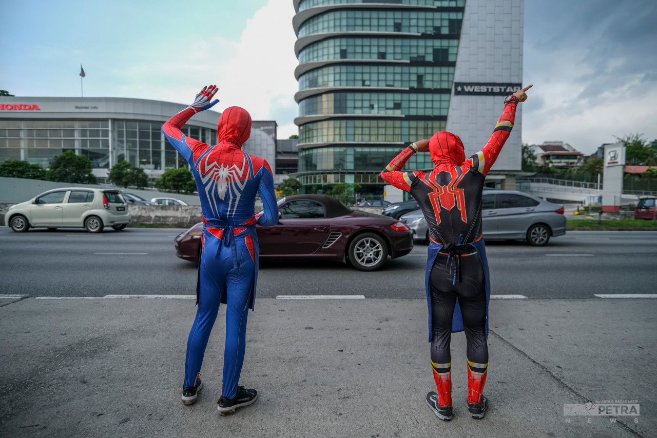 In addition to being able to buy cold Avengers tea, road users were also entertained by the behaviour of the two friends in their Spiderman costumes. – ABD RAZAK LATIF/The Vibes pic, April 27, 2022