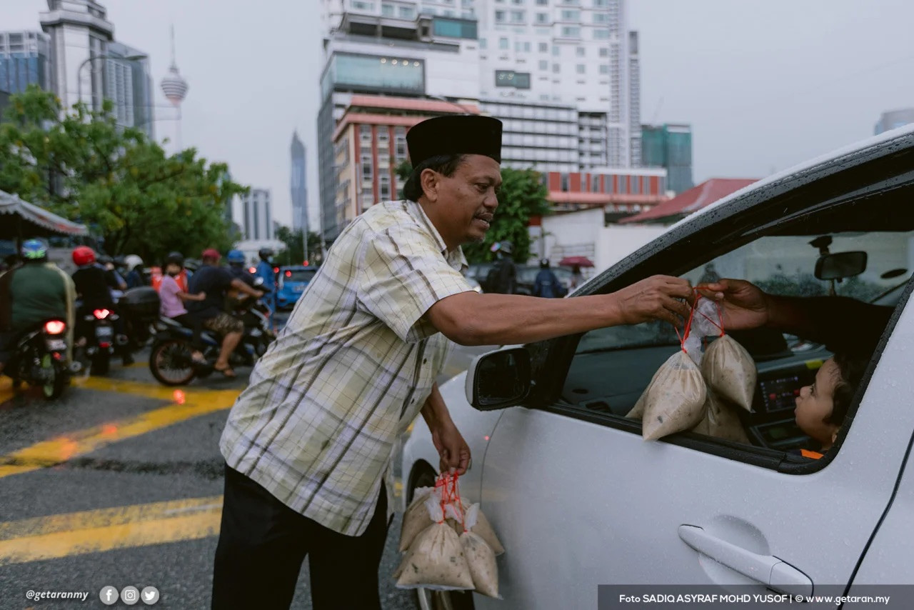 A mosque volunteer distributing bubur lambuk. – File pic