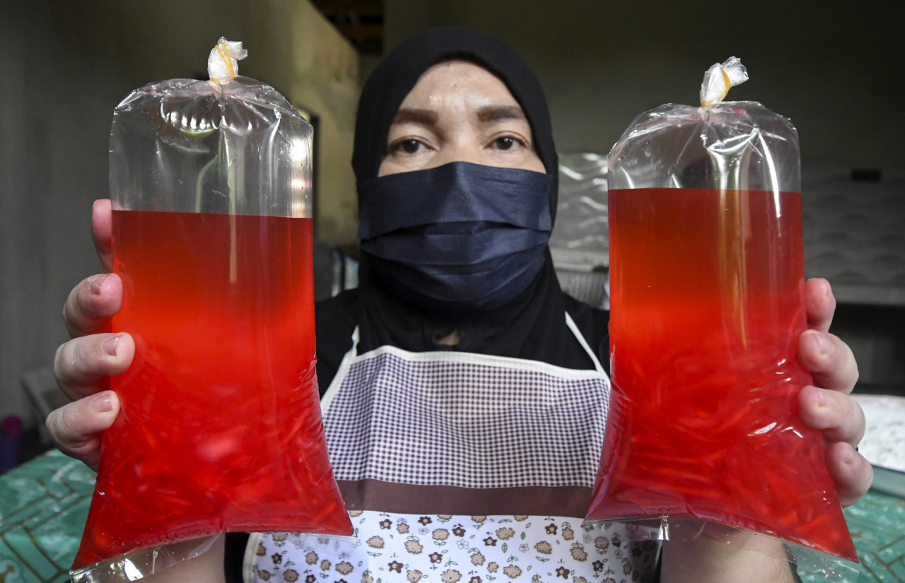 Mariani showing some of the locong that are packed for sale to customers. – Bernama pic