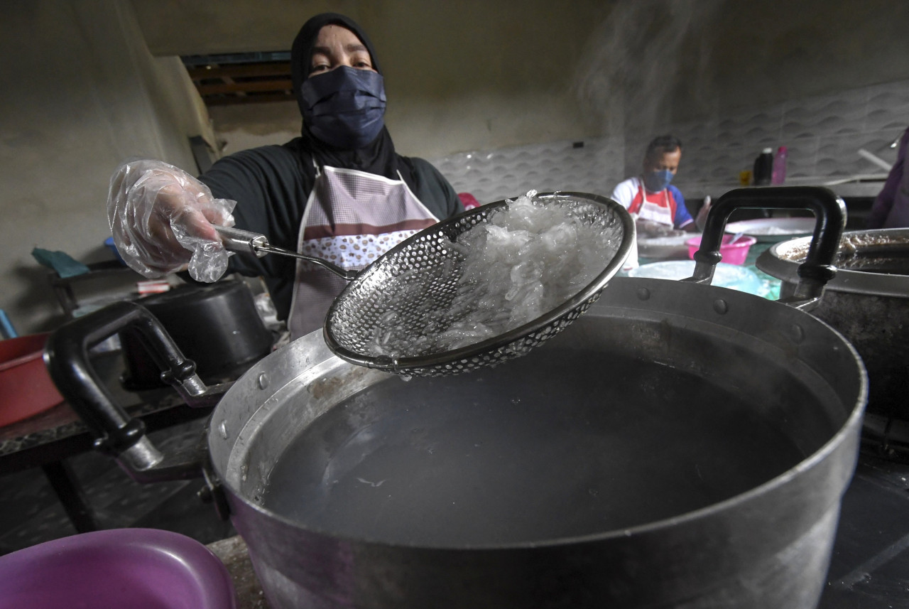Mariani showing some locong that had been cooked before being coloured and packed for sale to customers at Kampung Kebakat, Wakaf Bharu. – Bernama pic