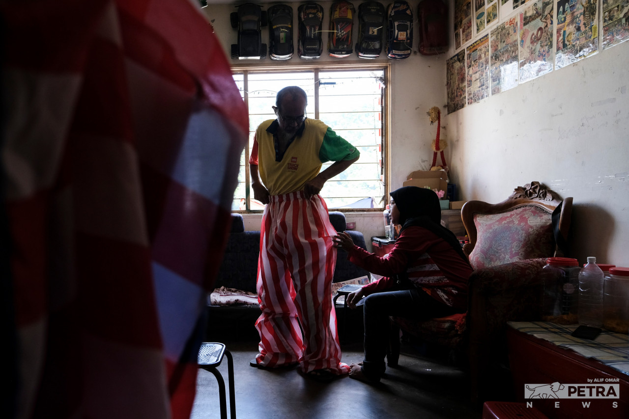 Uncle Ting Tong, whose real name is Roslee Yusop, prepares for another day of stilt-walking. He has replaced his usual clown costume with one that bears the design of the Jalur Gemilang in conjunction with this year’s Merdeka celebration. – ALIF OMAR/The Vibes pic, August 31, 2022