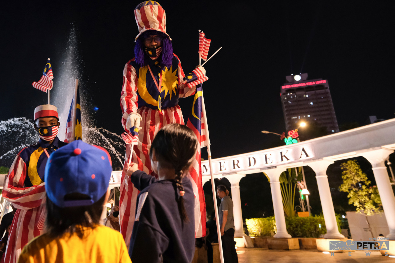Young children at Dataran Merdeka are delighted by the presence of the Jalur Gemilang-clad stilt-walking clown. – ALIF OMAR/The Vibes pic, August 31, 2022