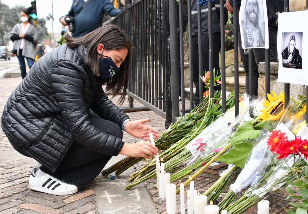 A fan lights a candle outside of the hotel where Foo Fighters' drummer Taylor Hawkins died, on March 26, 2022 in Bogotá. – AFP pic