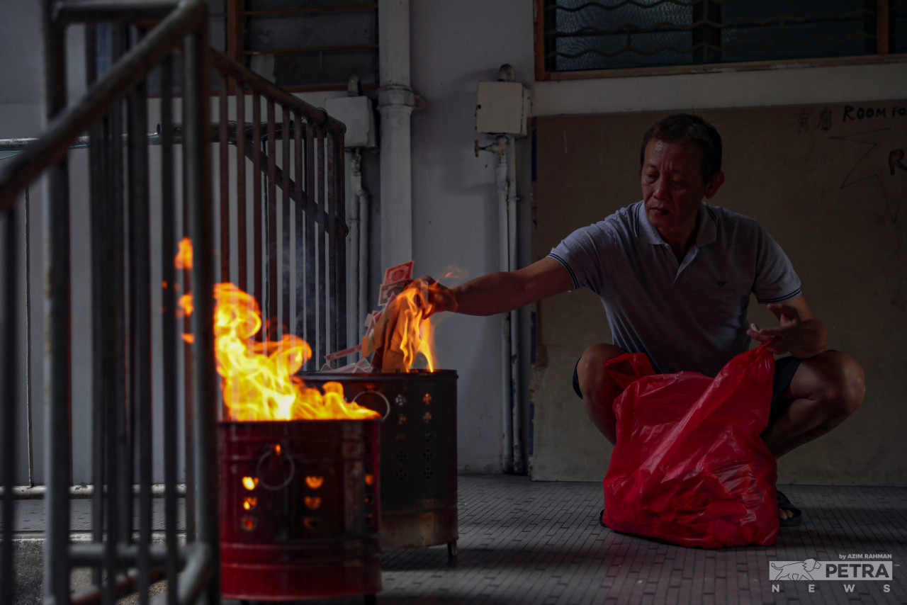 Soh Swee Huat prays and burns joss paper before the reunion dinner with family at his home in Jalan Tong Shin Flat. – AZIM RAHMAN/The Vibes pic, February 1, 2022