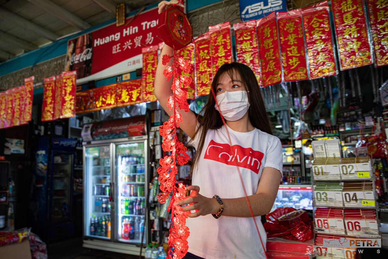 A trader displaying Chinese New Year decorations sold at her grocery store in Pulau Ketam. – SAIRIEN NAFIS/The Vibes pic, January 31, 2022