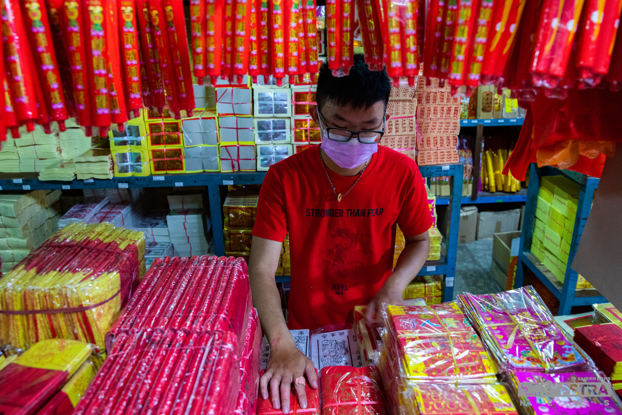 A trader arranges prayer items at a shop in Pulau Ketam in preparation for the Chinese New Year festival. – SAIRIEN NAFIS/The Vibes pic, January 31, 2022